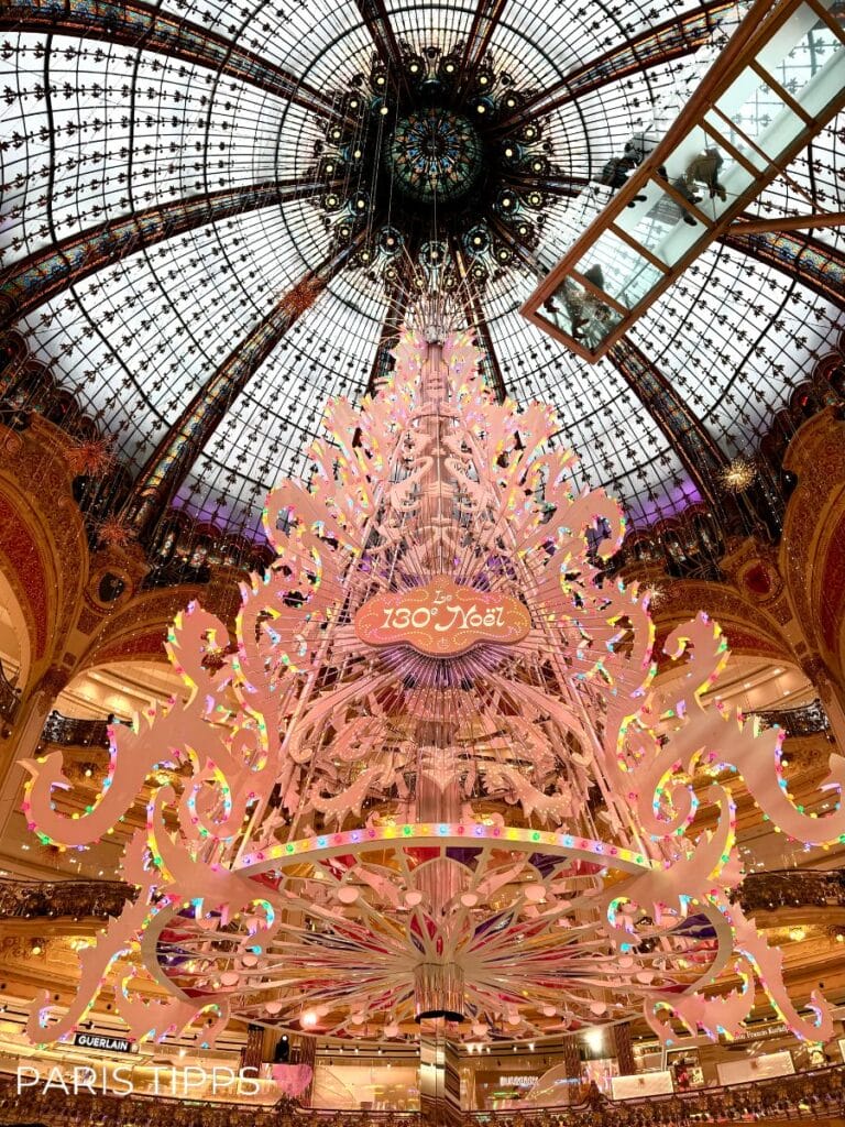 Weihnachtsbaum in der Galeries Lafayette 2024 - mit einem Emblem dass darauf hinweist, dass es das 130. Weihnachten in der Galeries ist