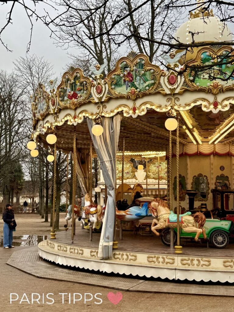historisches Karussell im Jardin des Tuileries, grauer Himmel, kahle Bäume.