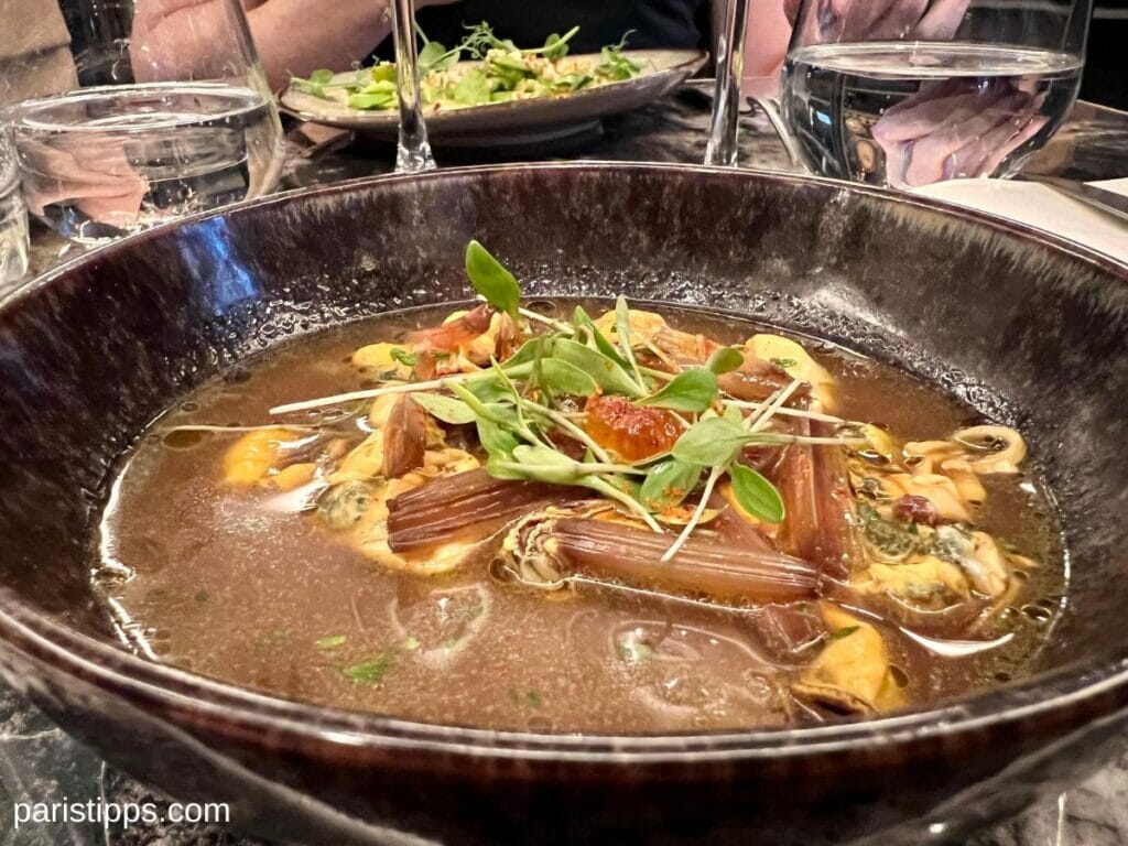 Restaurant Paris: lecker essen in Paris, hier im Restaurant Le Grand Dictionnaire, Muschelsuppe mit Rhabarber, verziert mit grünen Kräutern.