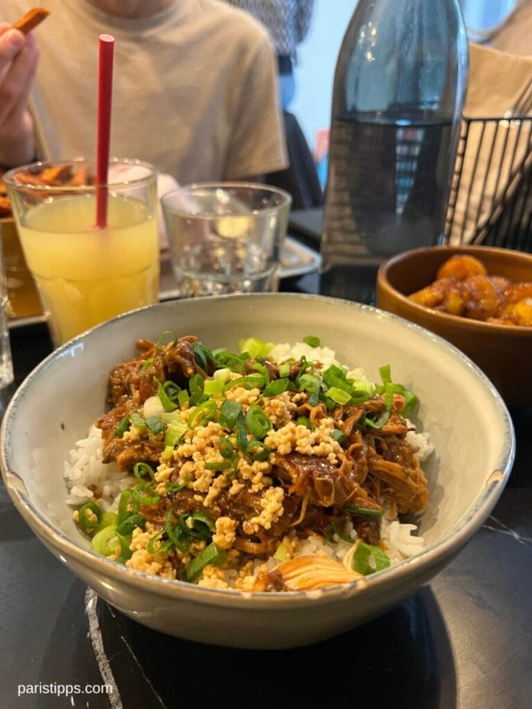 Reis mit Chicken Colombo und Limonade im Hintergrund. Restaurants in PAris müssen nicht teuer sein.